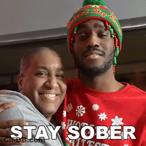 Man In Red Sweater Hugging Woman In Green And Red Hat GIF