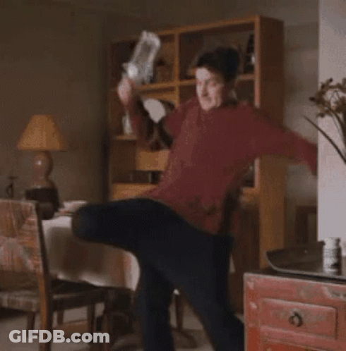Man In Red Sweater Standing In Living Room GIF