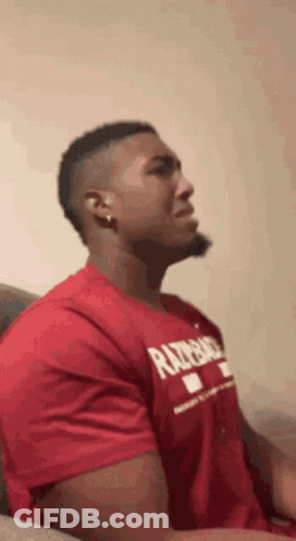Man In Red T-Shirt Sitting With Eyes Closed GIF