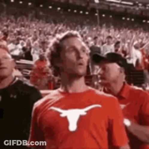 Man In Red T-Shirt With Longhorn In Crowd GIF