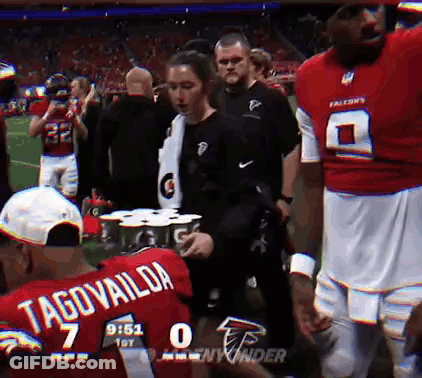 Man In Red Tagovailoa Jersey Holding Gatorade Can GIF