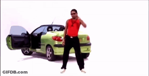 Man In Red Tank Top In Front Of Green Car GIF