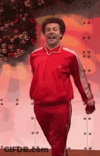 Man In Red Tracksuit Walking By Christmas Tree GIF