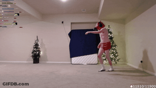 Man In Red Underwear Dancing In Front Of Christmas Tree And Blue Blanket GIF
