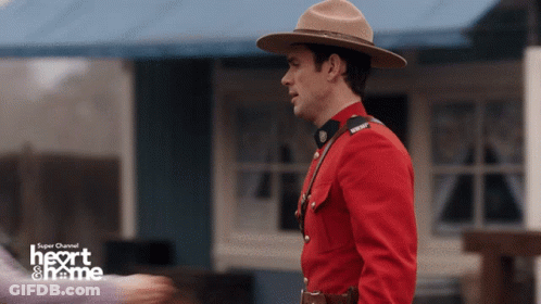 Man In Red Uniform In Front Of Heart & Name Building GIF
