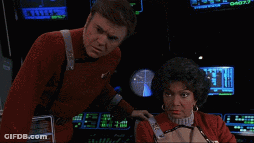Man In Red Uniform Next To Woman At Computer Screen Saying 040.7 GIF