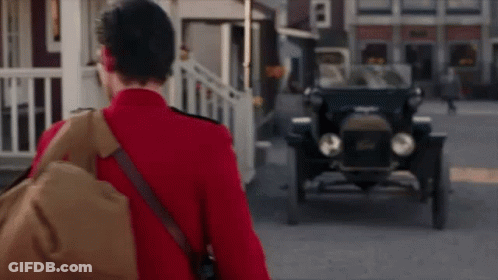 Man In Red Uniform Walking Toward Old Car GIF