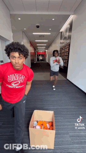 Man In Red Univ Football Shirt Next To Beer Cups Box GIF