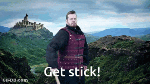 Man In Red Vest By Mountain Saying Get Stick GIF