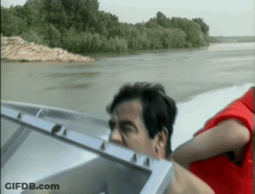 Man In Red Vest Driving Boat GIF