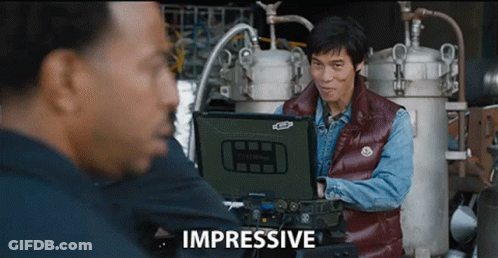Man In Red Vest Looking At Impressive Laptop GIF