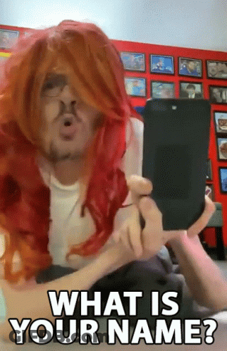 Man In Red Wig Holding Cell Phone Asking What Is Your Name GIF
