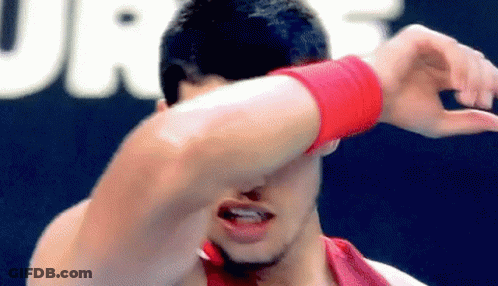 Man In Red Wristband Covering Face GIF