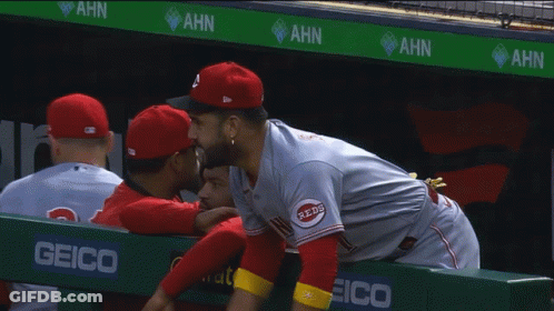 Man In Reds Jersey Hugging Another In Dugout GIF