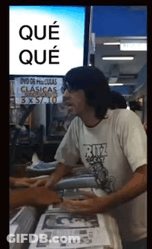Man In Ritz Shirt In Front Of DVD De Peliculas Clasicas Sign GIF