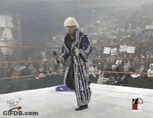 Man In Robe Holding Microphone In Wrestling Ring GIF
