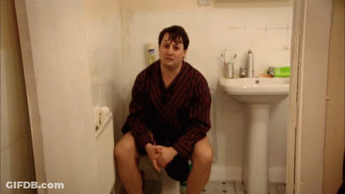 Man In Robe On Toilet Beside Bathroom Sink GIF