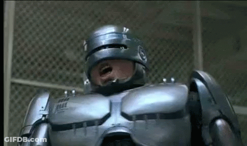 Man In Robot Suit Standing At Fence Mouth Open GIF