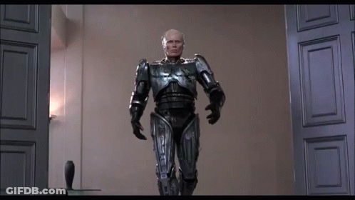 Man In Robot Suit Standing In Room GIF
