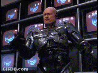 Man In Robotic Suit In Front Of TV Wall GIF