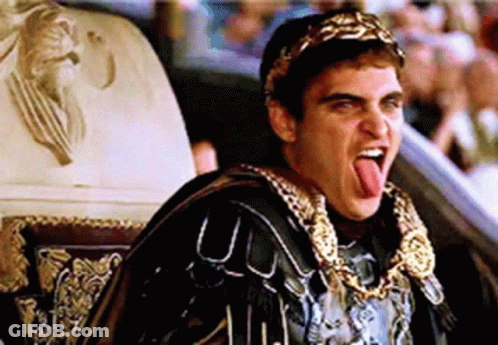 Man In Roman Costume Sticking Tongue Out In Crowd GIF
