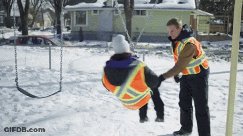 Man In Safety Vest Pushing Child On Swing GIF