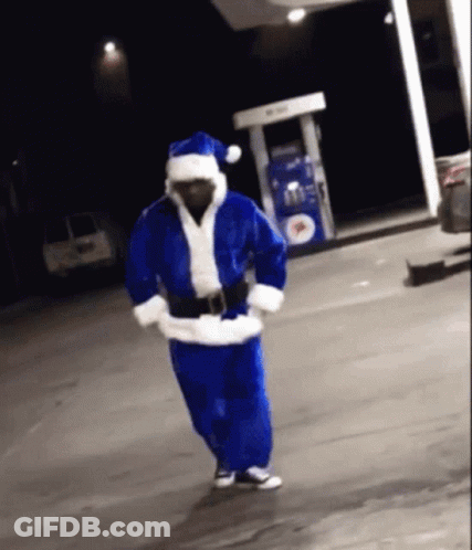 Man In Santa Costume Dancing In Front Of Gas Pump GIF