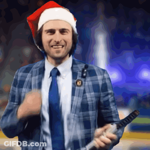 Man In Santa Hat And Plaid Suit Holding Microphone GIF