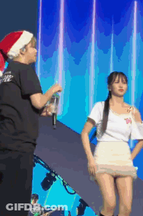 Man In Santa Hat Next To Woman GIF