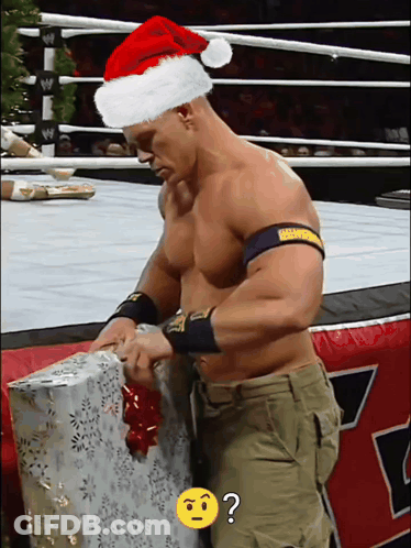 Man In Santa Hat Opening Gift GIF