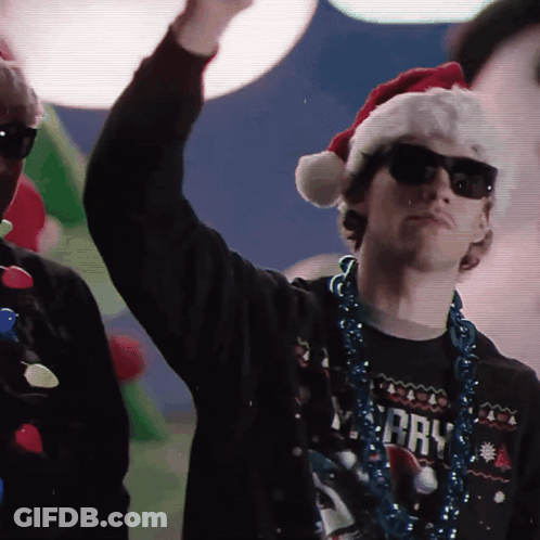 Man In Santa Hat, Sunglasses, And Merry Shirt GIF
