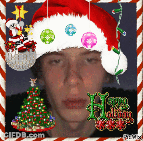 Man In Santa Hat Surrounded By Christmas Decorations And Tree GIF