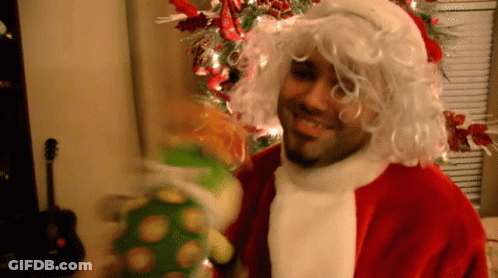 Man In Santa Suit Holding Stuffed Animal GIF