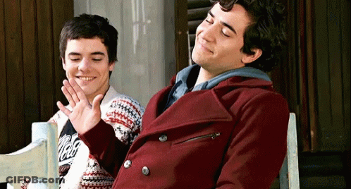 Man In Santa Suit Laying In Snow With Arms Outstretched GIF
