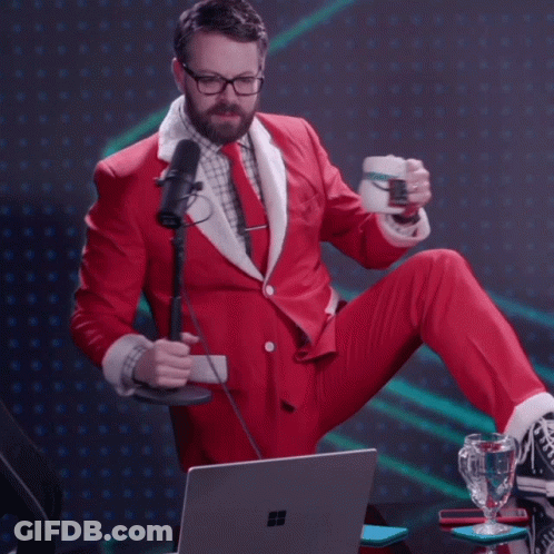Man In Santa Suit Sitting At Laptop Holding Cup GIF