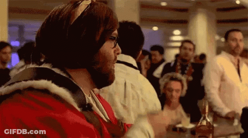 Man In Santa Suit Sitting With Bottle GIF