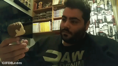 Man In Saw Denim Shirt Holding Pop Figure GIF