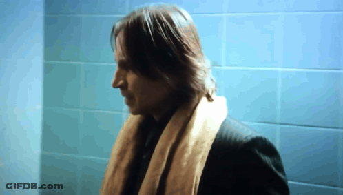 Man In Scarf In Front Of Blue Wall GIF