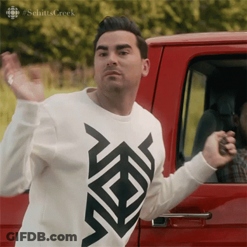 Man In Schitts Creek Sweater In Front Of Red Vehicle GIF