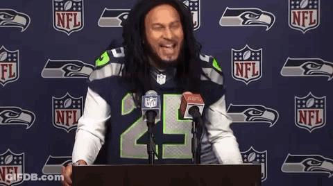 Man In Seahawks Jersey At Podium In Front Of NFL Logo GIF