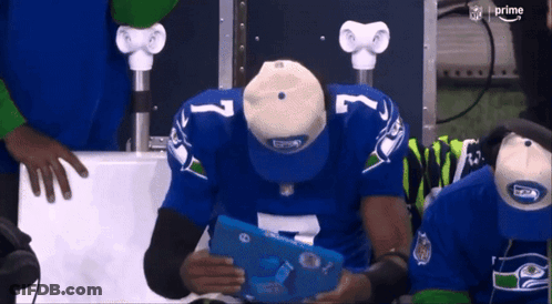 Man In Seahawks Jersey Looking At Tablet GIF