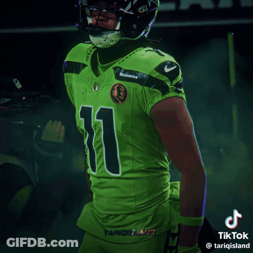 Man In Seahawks Uniform Smiling In Front Of Scoreboard Saying 1:49 GIF