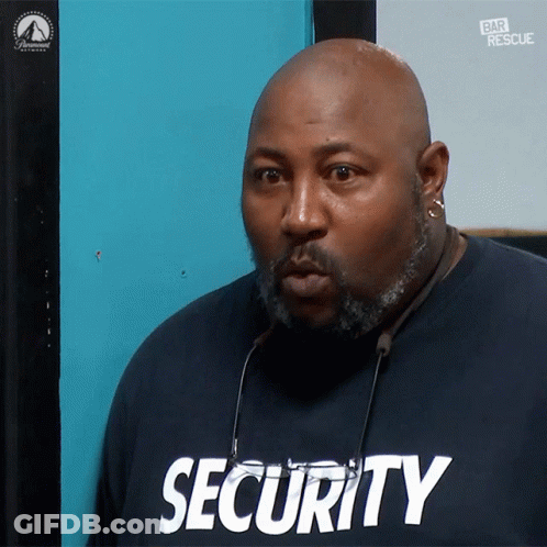 Man In Security Shirt Looking At Camera GIF