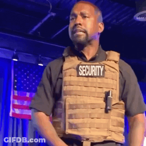 Man In Security Vest Standing On Stage GIF