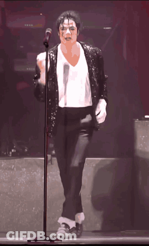 Man In Sequined Jacket And White Gloves Singing Into Microphone GIF