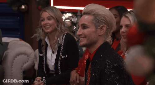 Man In Sequined Jacket Smiling Next To Woman GIF