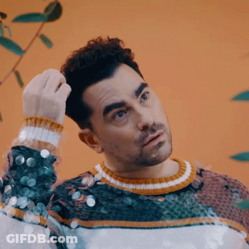 Man In Sequined Sweater Scratching Hair GIF