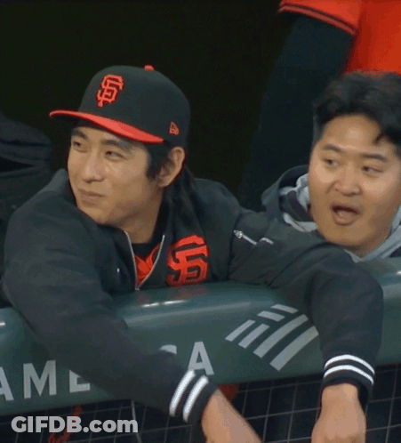 Man In SF Hat Leaning Over Fence GIF