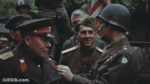 Man In SG Helmet Talks To Soldier GIF