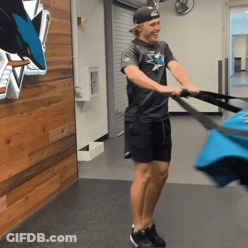 Man In Sharks Shirt Pulling Bag GIF